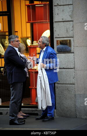 Milan, Pietro Lorenzetti walking with his wife in the center Professor Pietro Lorenzetti, renowned plastic surgeon who has several studies throughout Italy, often frequents Barbara D'Urso's living room on Sunday Live on channel 5 when ALBERICO LEMME, discussed the character who always argues for his method of slimming with his diets (several characters from the world of entertainment have entrusted to him, primarily Silvio Berlusconi and Briatore). He is surprised to walk through the streets of the quadrilateral while curious among the showrooms of the boutiques, along with his wife and a frie Stock Photo