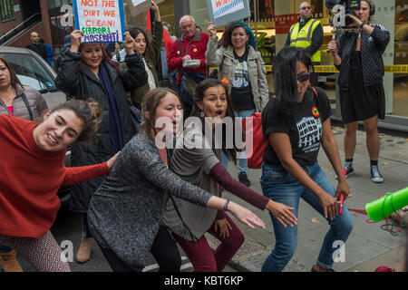 September 30, 2017 - London, UK. 30th September 2017. Protesters dance outside the Ferrari showroom of Kensington luxury car dealers HR Owen at the United Voices of the World trade union protest demanding they reinstate their two cleaners suspended without pay because they asked to be paid a the London living wage for cleaning the Ferrari/Maserati showrooms. Cleaners Angelica Valencia and Freddy Lopez were supported by the UVW, and other groups including Class War and the RCG. Around a hundred protesters marched from South Kensington station, protesting briefly outside the Lamborghini showro Stock Photo