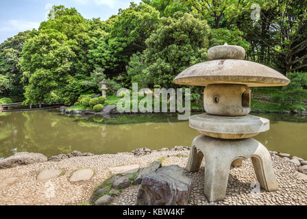 Stone lantern at the Japanese Garden at Shinjuku Gyoen National Garden, Tokyo, Japan Stock Photo