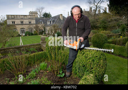 Andrew Tolman testing the Stihl HSA 56 hedgetrimmer at The Coach House, Ampney Crucis, Gloucestershire. Stock Photo