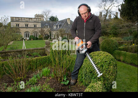 Andrew Tolman testing the Stihl HSA 56 hedgetrimmer at The Coach House, Ampney Crucis, Gloucestershire. Stock Photo