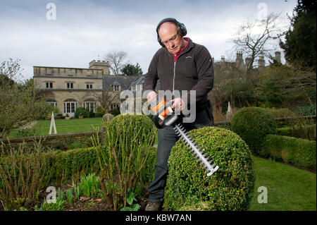 Andrew Tolman testing the Stihl HSA 56 hedgetrimmer at The Coach House, Ampney Crucis, Gloucestershire. Stock Photo