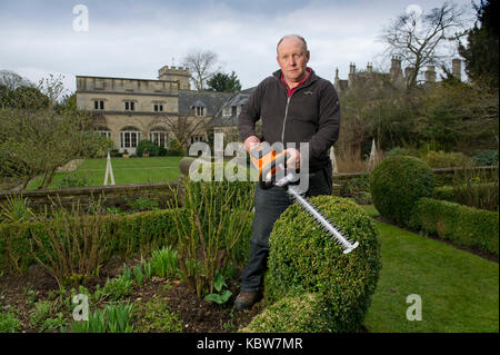 Andrew Tolman testing the Stihl HSA 56 hedgetrimmer at The Coach House, Ampney Crucis, Gloucestershire. Stock Photo