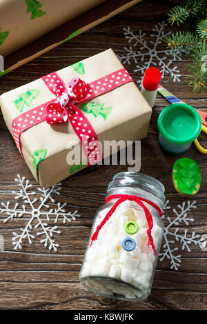 Child draws details of Christmas gifts box and snowman sweets. Made by own hands. Children's art project for children. Craft for kids. Stock Photo