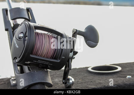 Close up of a lead core fishing reel in a rod holder on a boat