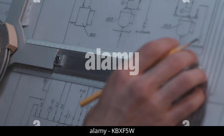 Close up of Architect hand sketching a construction project at work place. repair, building and home concept - close up of male hands making changes to blueprint. Stock Photo