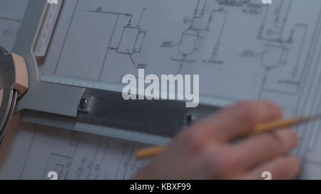 Close up of Architect hand sketching a construction project at work place. repair, building and home concept - close up of male hands making changes to blueprint. Stock Photo