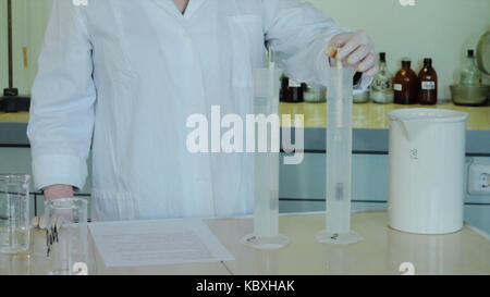 Close-up partial view of scientists making experiment with reagent and flasks. close up of biotechnology research in laboratory Stock Photo