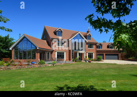 Simon & Gail Abdilla with daughter Sophie, with their new self-build house in Exton, Devonshire, UK Stock Photo