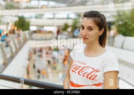 LISBON, PORTUGAL - AUGUST 10, 2017: Young Girl Wearing White Shirt With 'Drink Coca-Cola' Slogan Sign In Modern Shopping Mall. Stock Photo