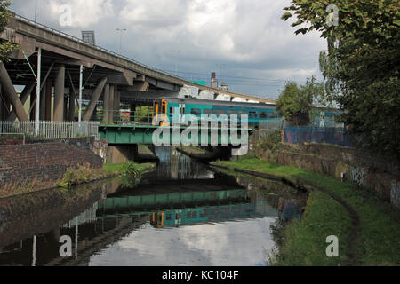 A Arriva Wales diesel multiple unit passenger train crosses a canal deep in the heart of the Black Country near Smethwick. Stock Photo