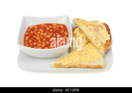 Baked beans in a bowl with buttered toast on a plate isolated against white Stock Photo