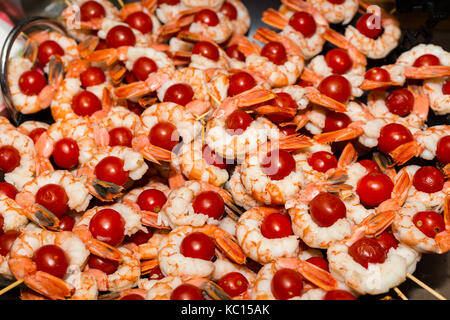 Appetizing cooked shrimps with tomatoes on skewers at food festival, food and beverage concept Stock Photo