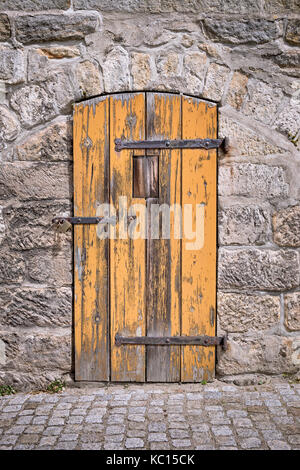 Orange door in stone wall Stock Photo