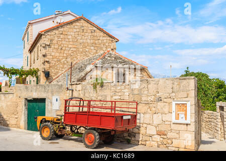 POSTIRA TOWN, CROATIA - SEP 7, 2017: Old tractor parking on street in Postira old town, Brac island, Croatia. Stock Photo