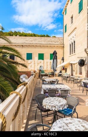 PUCISCA TOWN, CROATIA - SEP 7, 2017: Tables on cafe terrace in Pucisca town, Brac island, Croatia. Stock Photo