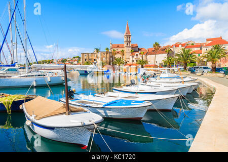 Fishing boats and view of beautiful church in Milna port on sunny summer day, Brac island, Croatia Stock Photo