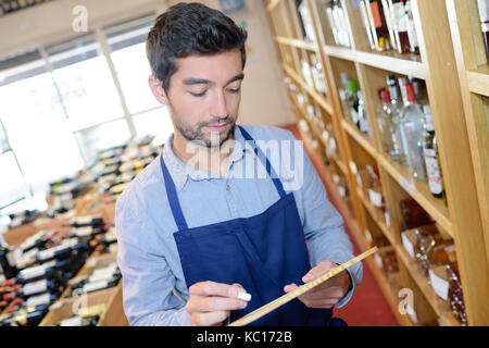 salesman taking inventory in wine shop Stock Photo