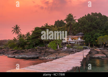 Wooden pier to a tropical island resort on Koh Kood island during sunset, Thailand.