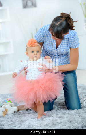 mother dressing a baby girls hair Stock Photo