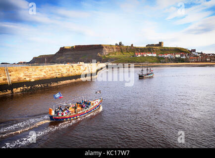 The 'Bark Endeavour' a replica of Captain Cook's sailing ship, passing the Old Lifeboat,  Whitby Harbour, Yorkshire, England Stock Photo