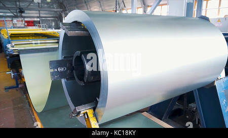Rolled steel. Stack of rolls, Cold rolled steel coils in action. Galvanized Steel Sheet and rusty rim. Cold rolled steel coils. he drum turns the metal sheets in the production. Industrial Stock Photo