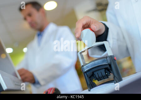 hospital worker stamping document Stock Photo