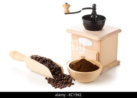 Coffee beans in wooden scoop and ground coffee in wooden bowl with coffee bean grinder over white background Stock Photo