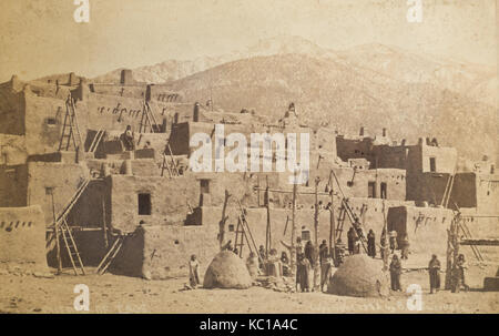 American late 19th century mounted monochrome photograph dated 1878 of the Santa Fe Route, showing Taos Pueblo, New Mexico, photograph taken by B H Guernsey, with Native American Indians and adobe mud houses with mountains in the background Stock Photo