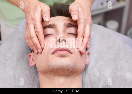 Handsome guy, face massage. Stock Photo