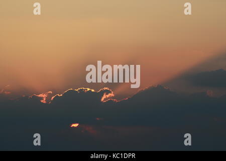 Beautiful sunset through the clouds Stock Photo
