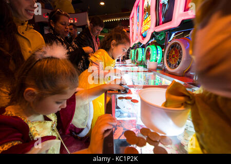 Young children playing penny arcade gambling machines in Blackpool Coral Island. Credit, LEE RAMSDEN / ALAMY Stock Photo