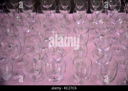 pink tablecloth with empty white wine glasses, empty glasses in a row Stock Photo