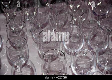 a group of empty white wine glasses on white tablecloth, empty glasses in a row Stock Photo