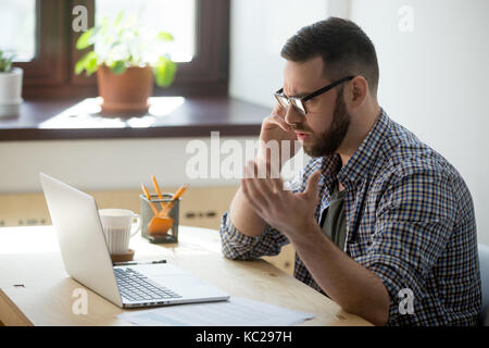 Joiner polishes wooden board in workshop Stock Photo