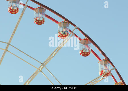 An attraction of a Ferris wheel against a blue sky background. The cabin of Ferris wheels closeup. Stock Photo