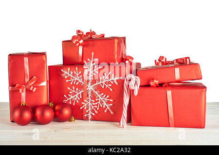 Pile of red gift boxes on white wooden table. Stock Photo