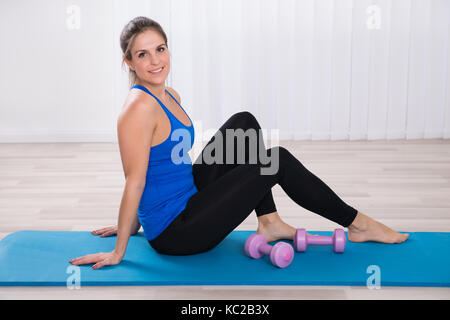 Happy woman, fitness and dumbbell exercise in gym for strong body