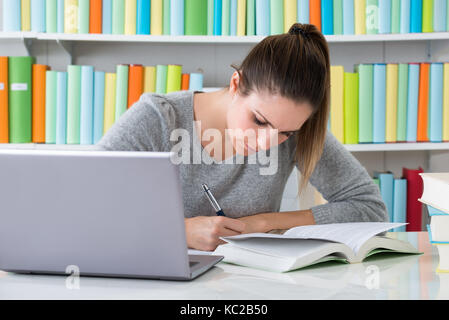 Photo Of Happy Young Woman Studying In Library Stock Photo