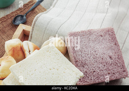 Many breads and cups of coffee on a tablecloth. Stock Photo