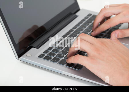 Close-up Of Person Hands Typing On Laptop Keyboard Stock Photo
