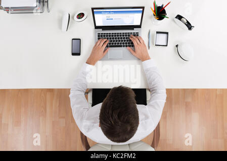 High Angle View Of Businessman Doing Login Of Online Account Using Laptop Stock Photo