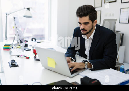 Portrait of young handsome working in office Stock Photo