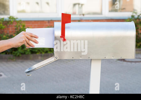 Close-up Of Person Removing Yellow Letters From Mailbox Stock Photo