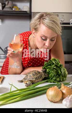 Female is surprised on tortoise who is eating salad Stock Photo