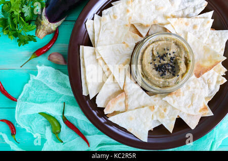 Light dietary pate from eggplant. Baba ganush is an Asian dish. Serve with thin lavash on a ceramic bowl. Top view. Stock Photo