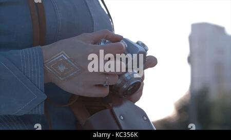 Girl's hands hold the vintage old film camera. Girl camera shutter clicks close up Stock Photo