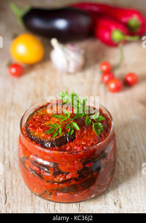 Appetizer from eggplants with paprika and tomato sauce. Rustic style, selective focus. Stock Photo