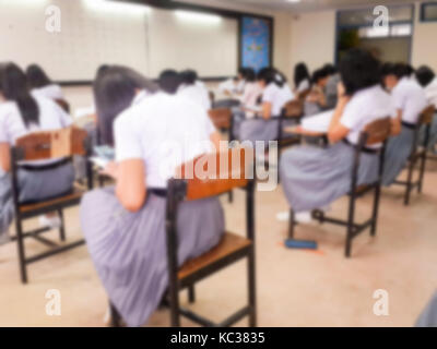 Blur school or university students writing answer doing exam in classroom. Stock Photo