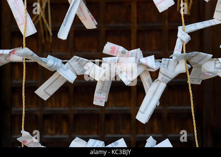 Kyoto, Japan - May 18, 2017: Paper prayers and wishes tied on a rope at the Yasaka jinja shrine in Kyoto Stock Photo
